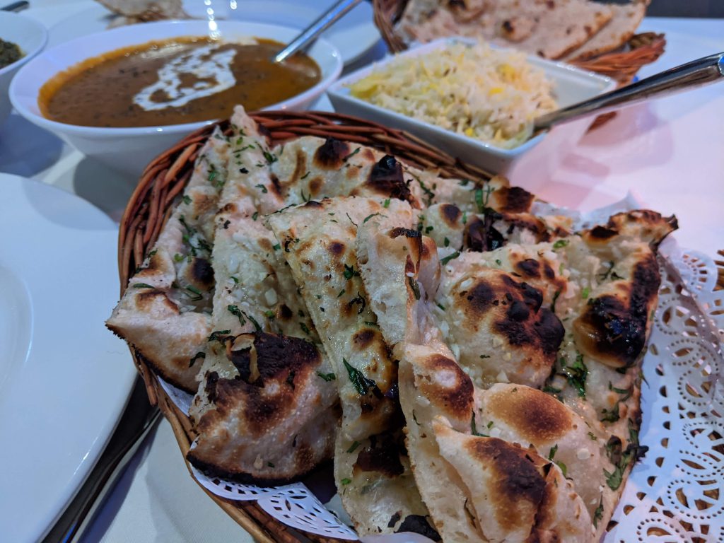 Garlic naan at the centre, with dal Baluchi and pilau rice in the background